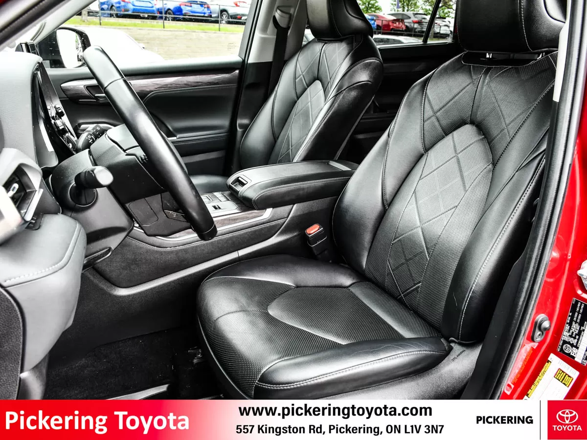 Interior view of the front seats, showcasing black leather upholstery with a diamond-stitched pattern of a red 2022 Toyota Highlander Hybrid Limited A