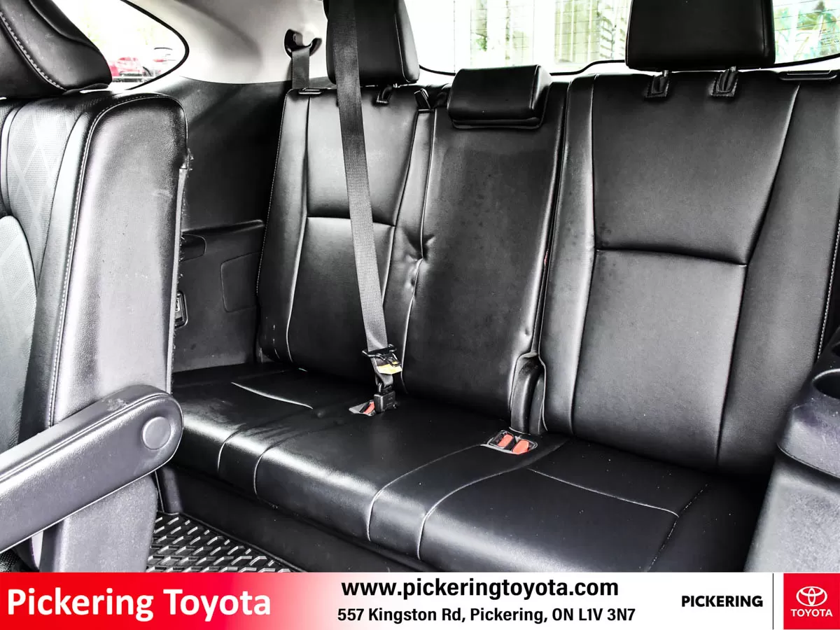Interior view of the rear seats in a red 2022 Toyota Highlander Hybrid Limited AWD SUV taken at Pickering Toyota dealership.