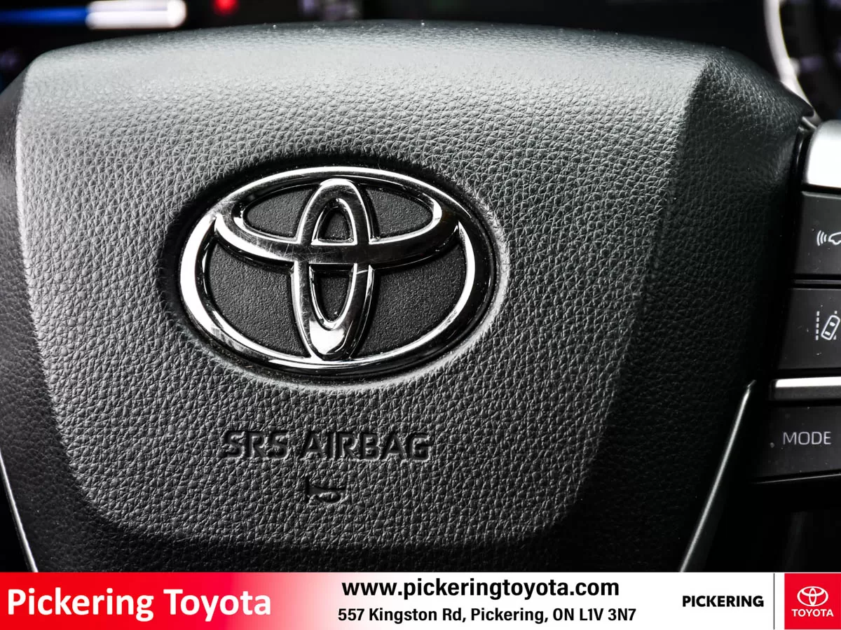 Close-up view of the Toyota logo on the steering wheel with SRS airbag detail of a red 2022 Toyota Highlander Hybrid Limited AWD SUV taken at Pickeri