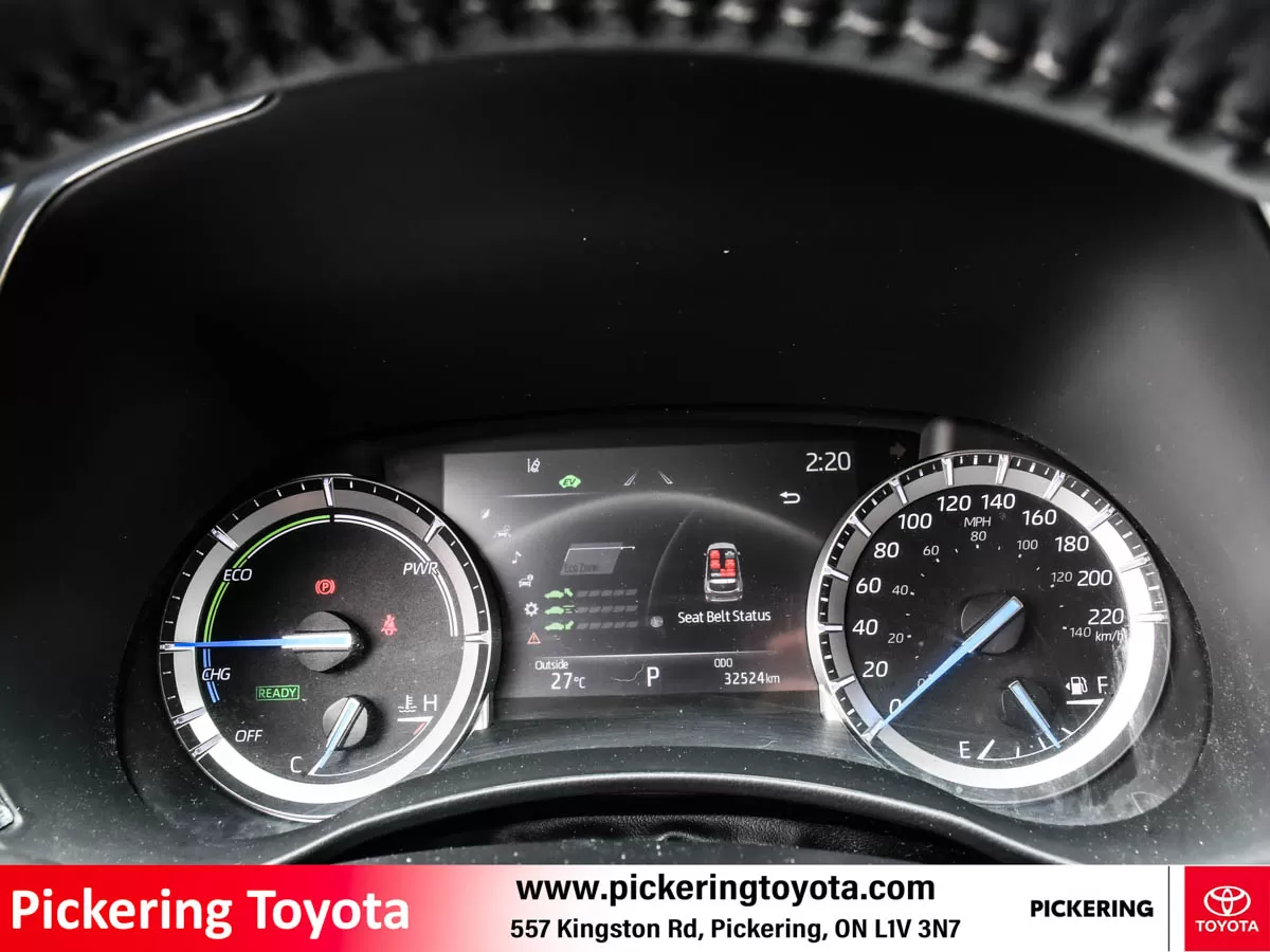 Dashboard display of a Toyota vehicle showing the speedometer, eco/power gauge, and a central digital screen with seat belt status, temperature, and m